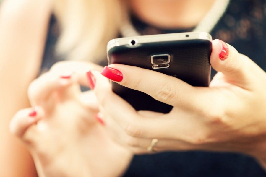 Woman sending text message from her smartphone