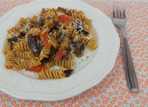 Piatto di pasta integrale bio con melanzane pomodorini e pecorino romano