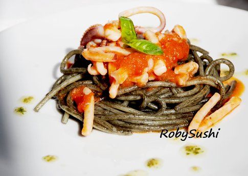 Spaghetti al nero di seppia con pomodoro e calamari. Ricetta e foto di Roberta Castrichella.