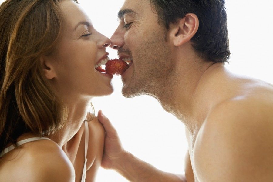 Couple Eating a Strawberry --- Image by © Brooke Fasani Auchincloss/Corbis