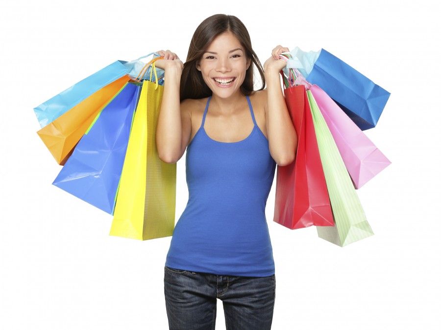 Shopper woman holding shopping bags. Young beautiful shopping woman during sale holding many colorful shopping bags isolated on white background in studio. Pretty multiracial Asian Chinese / Caucasian female model.