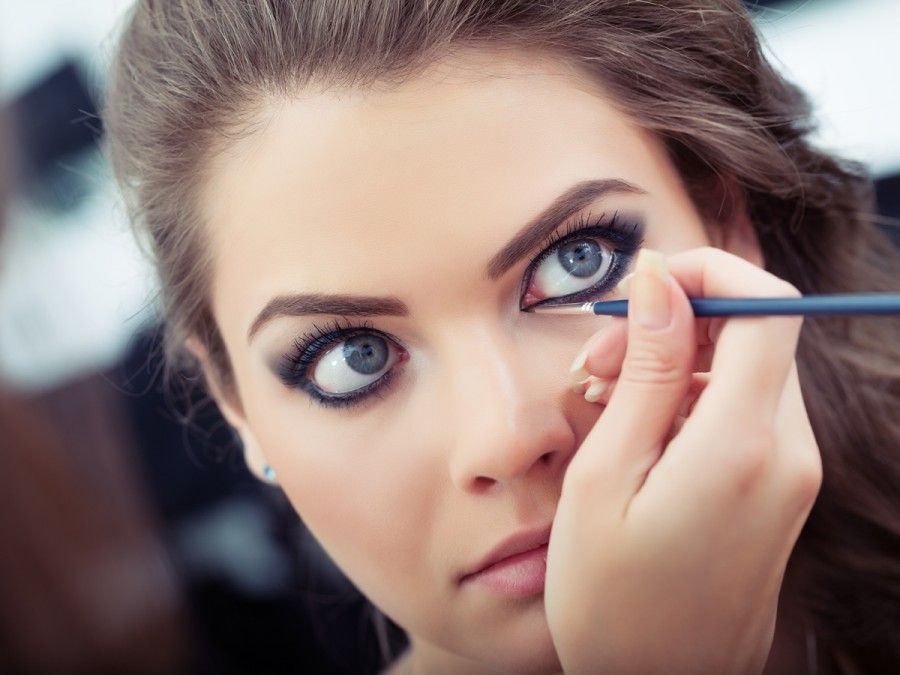 Make-up artist applying liquid eyeliner with brush, close up