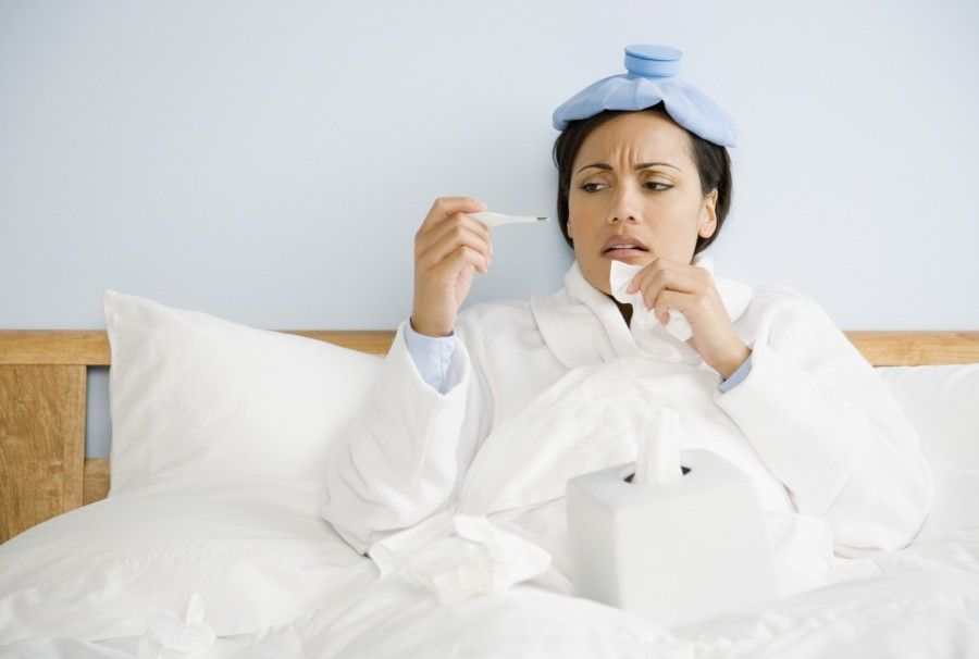 Sick African American woman checking temperature