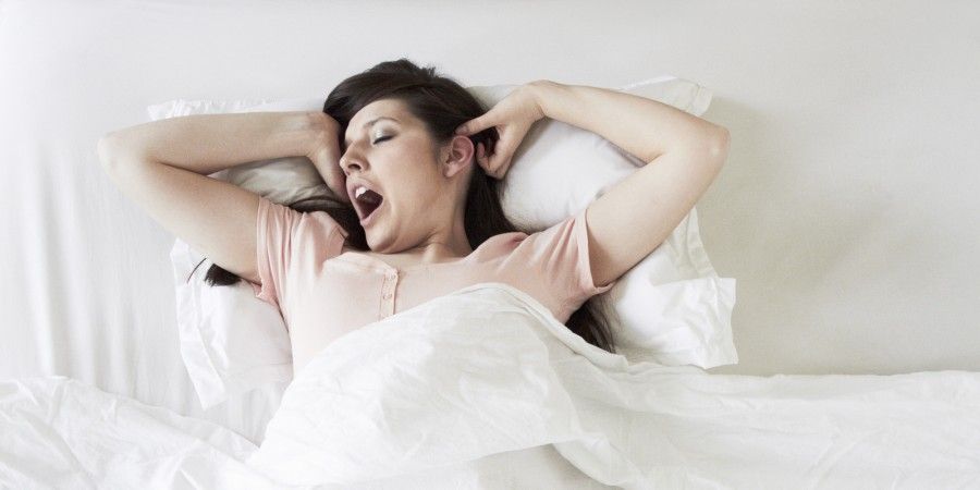 Woman waking and yawning in bed