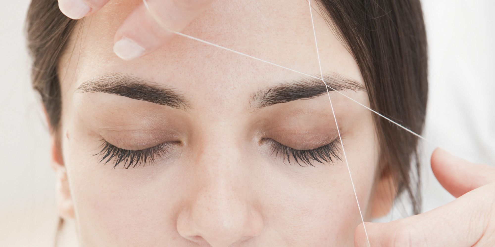 young woman having eyebrows Threaded