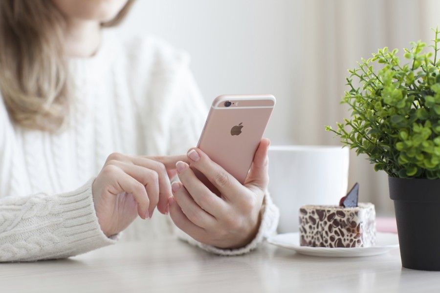 Alushta, Russia - October 25, 2015: Woman holding in the hand iPhone 6 S Rose Gold in cafe. iPhone 6S was created and developed by the Apple inc.