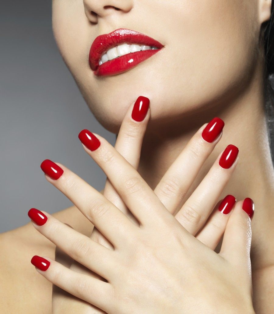 Young woman with fashion red nails and sensual lips - Model posing in studio