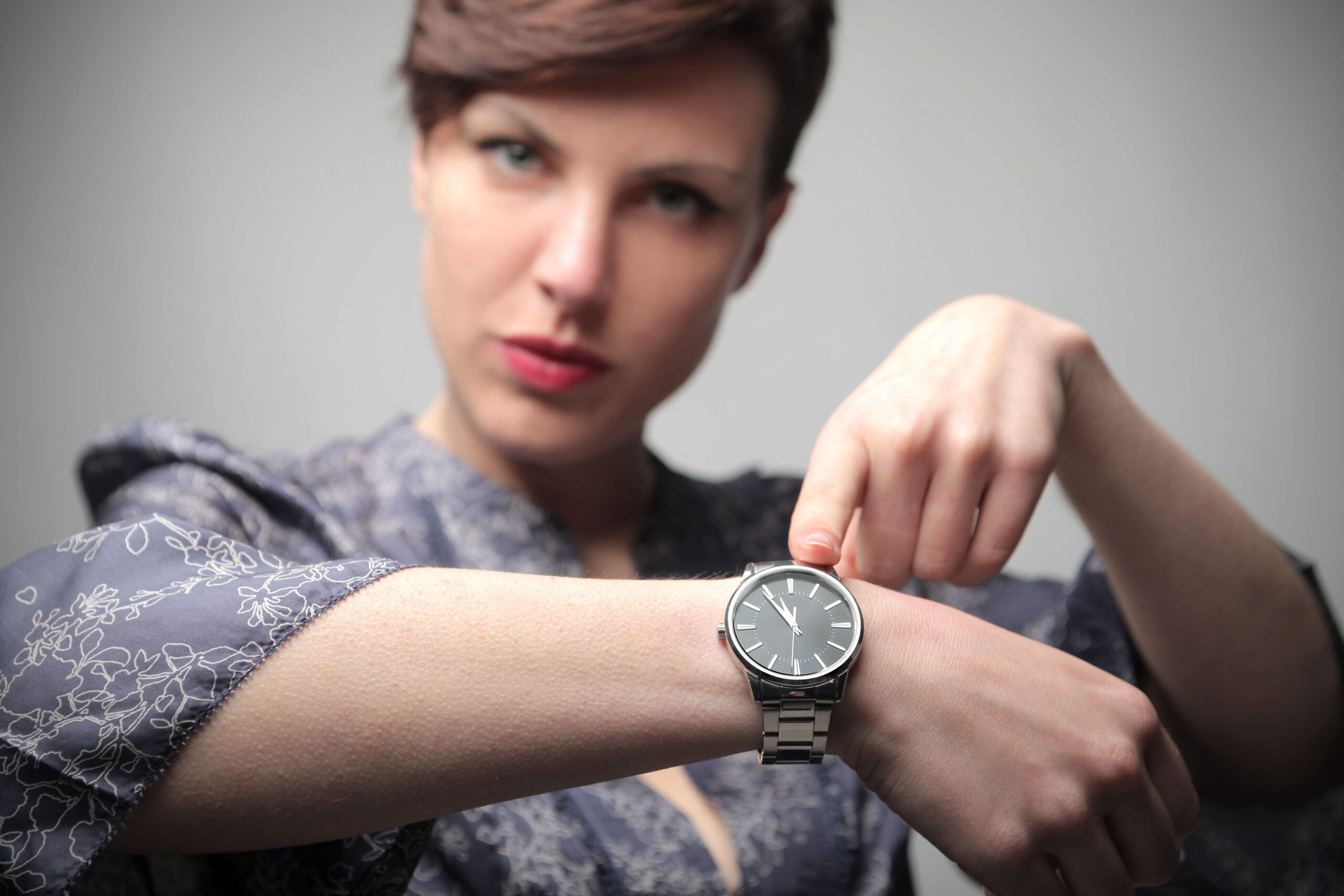 Женщина смотрит на часы. Пунктуальность. Девушка с наручніми часами. Показывает на наручные часы. Человек с часами.