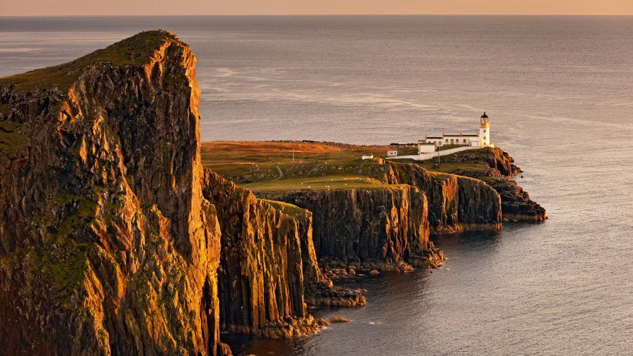 View of sea cliffs and lighthouse at sunset, Neist Point Lighthouse, Isle of Skye, Inner Hebrides, Scotland