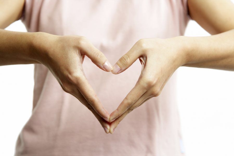 A woman's hands forming a heart symbol