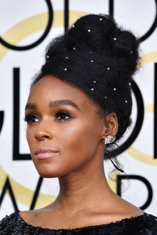 Chignon alto reso unico da piccole perle che creano dei punto luce sulla sua chioma corvina per Janelle Monae