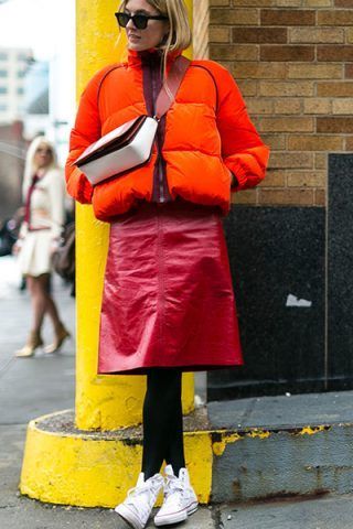 Piumino corto, gonna midi e sneakers