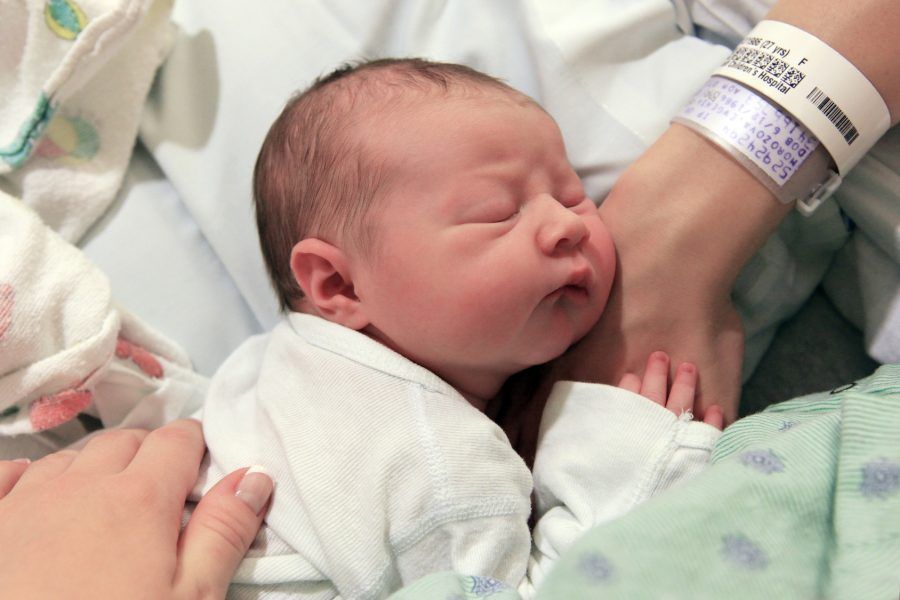 Sleeping newborn baby in the arms of my mother in hospital