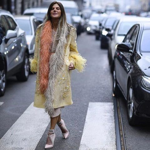 Anna Dello Russo opta per lo stile boudoir con piume, seta e vestaglia, in tono con le ciocche dei capelli. Per noi è OUT!