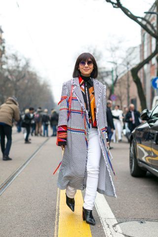 Cappotto e pantaloni bianchi con un tocco di colore.