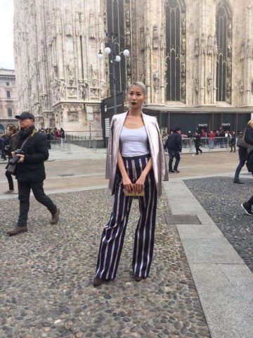 Look elegante e sofisticato con giacca perlescente e pantalone a righe a vita alta.