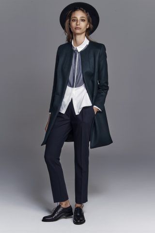 Look tomboy: pantaloni da uomo, gilet, camicia fuori e cappotto, con cappello a falde larghe