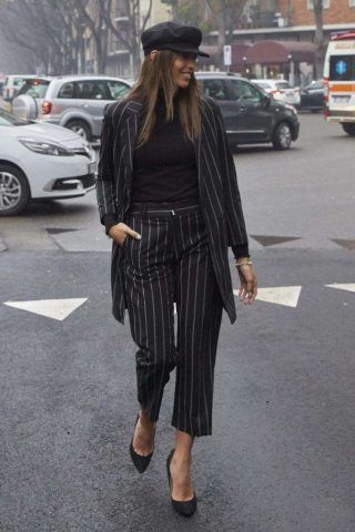 Sì al completo gessato con décolleté e cappellino.