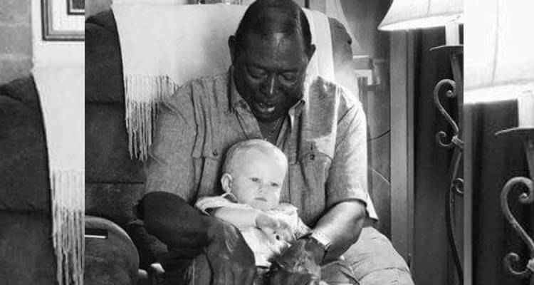 Il vicino prende in braccio il bambino, poi il padre scatta una foto per rivelare la vera identità dell’uomo