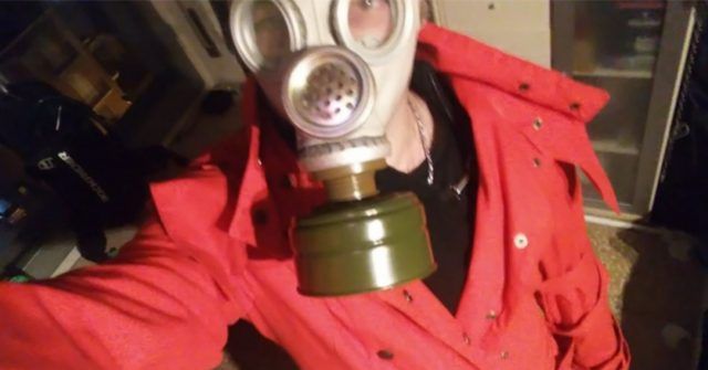 Uomo mantello rosso e maschera anti gas