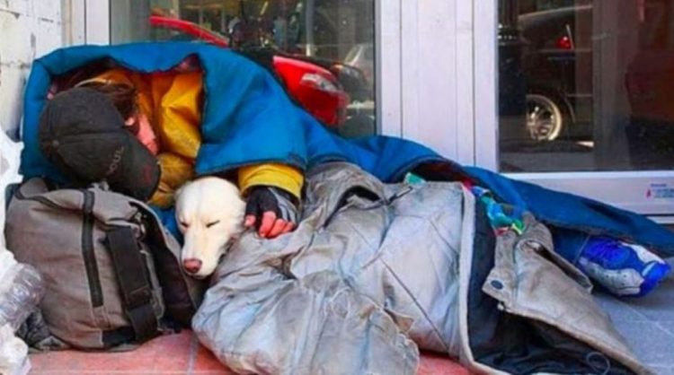 Senzatetto con il suo cucciolo di cane