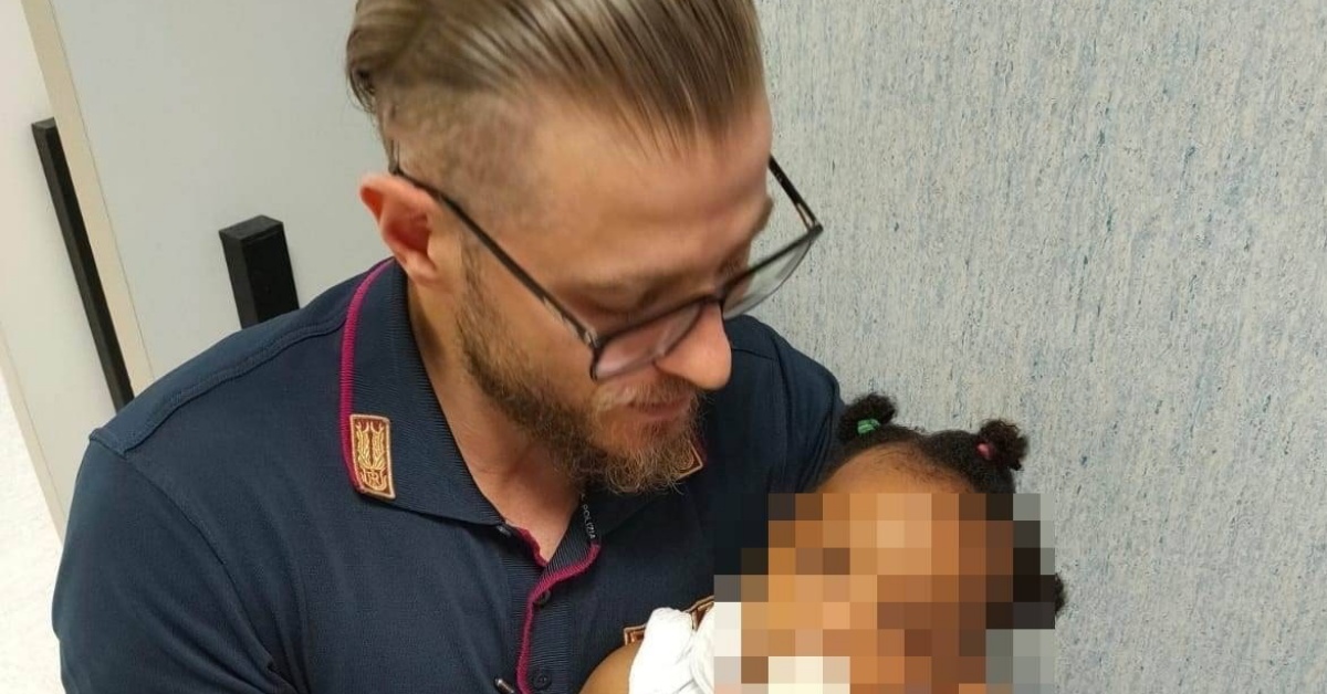 Poliziotto accudisce la bambina, mentre la mamma è in ospedale