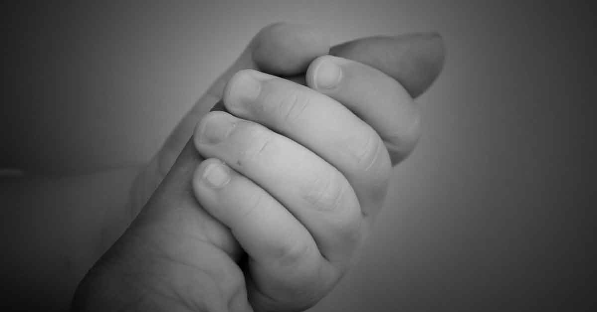 Bambina prega con il papà dandogli la mano