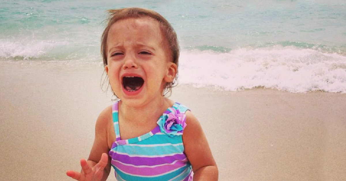 Bambina che piange in spiaggia