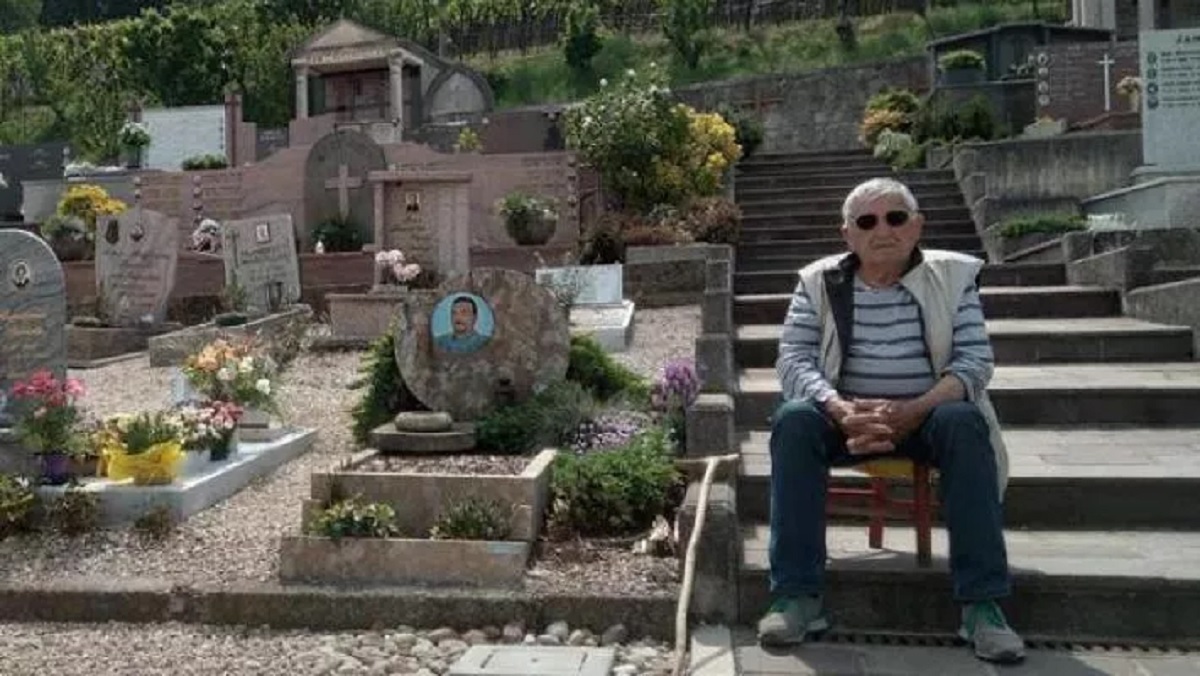 Father watches over the grave of his son who died of cancer